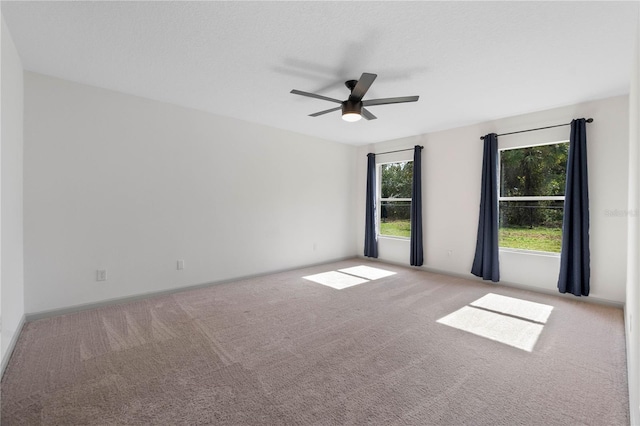 carpeted empty room featuring a ceiling fan