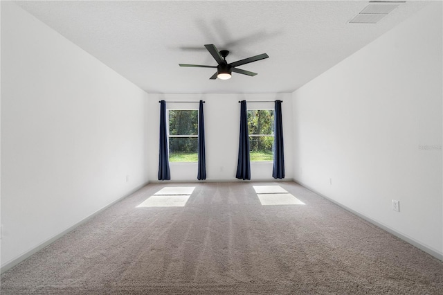 spare room with light carpet, ceiling fan, a textured ceiling, and visible vents