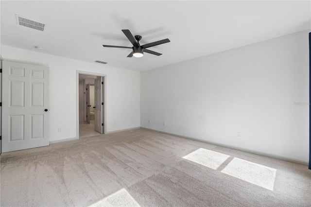 empty room with carpet floors, visible vents, baseboards, and a ceiling fan