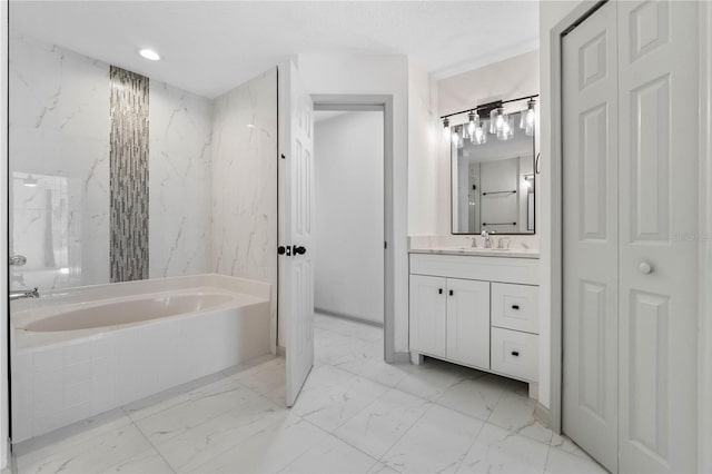 bathroom featuring marble finish floor, a closet, vanity, and a bath