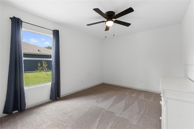 carpeted spare room with plenty of natural light, baseboards, and a ceiling fan