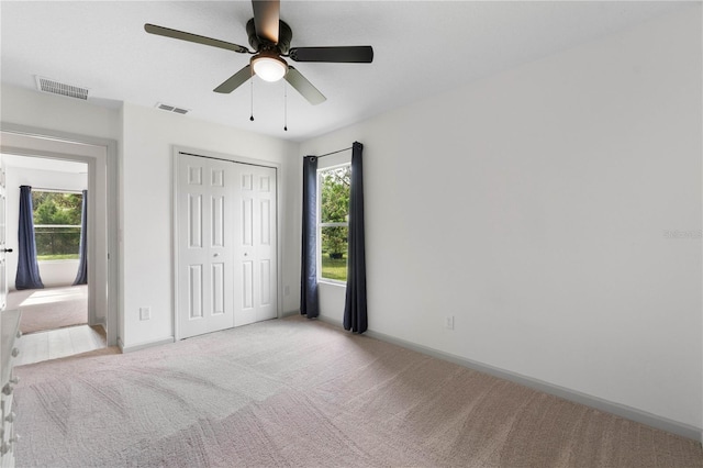 unfurnished bedroom featuring baseboards, carpet, visible vents, and a closet