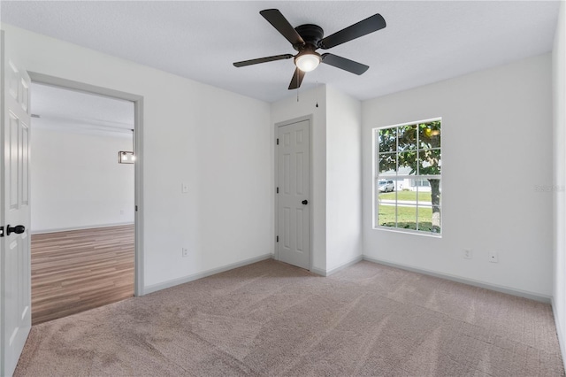 unfurnished bedroom with a ceiling fan, carpet flooring, and baseboards