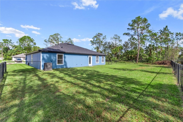 back of house with a yard, cooling unit, and a fenced backyard