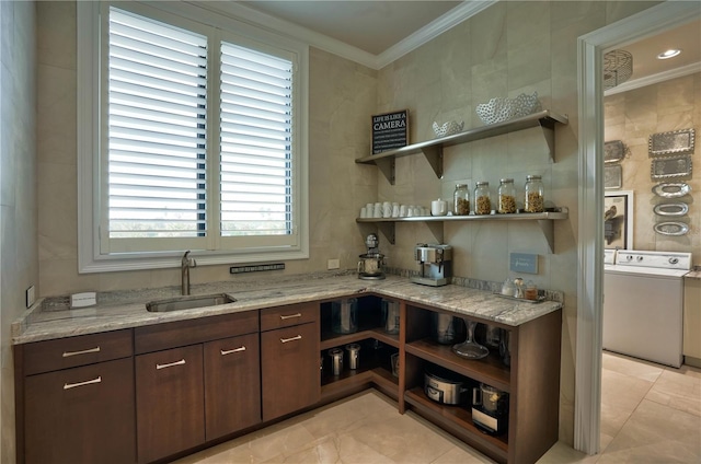 kitchen featuring sink, light tile patterned floors, light stone countertops, dark brown cabinetry, and washer / clothes dryer