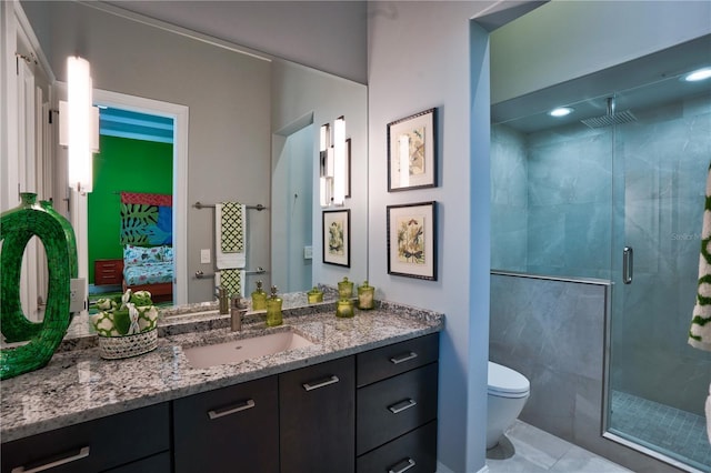 bathroom featuring an enclosed shower, vanity, toilet, and tile patterned floors