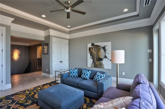 tiled living room featuring a tray ceiling, ceiling fan, and ornamental molding