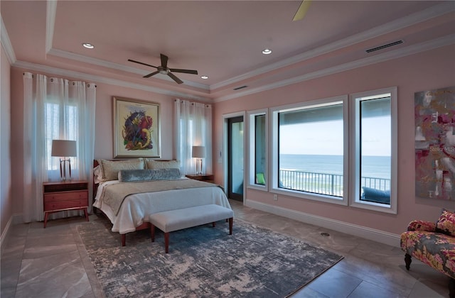 bedroom featuring ceiling fan, a water view, ornamental molding, and a tray ceiling