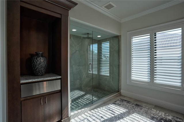 bathroom featuring tile patterned flooring, a shower with shower door, and crown molding