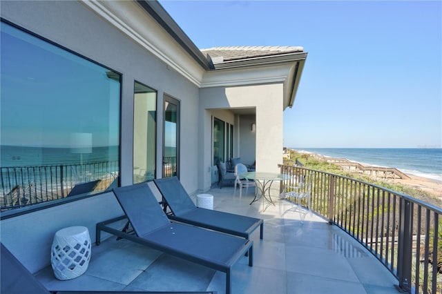 balcony featuring a water view and a view of the beach