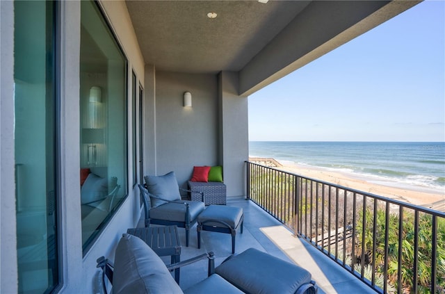 balcony featuring a water view and a beach view