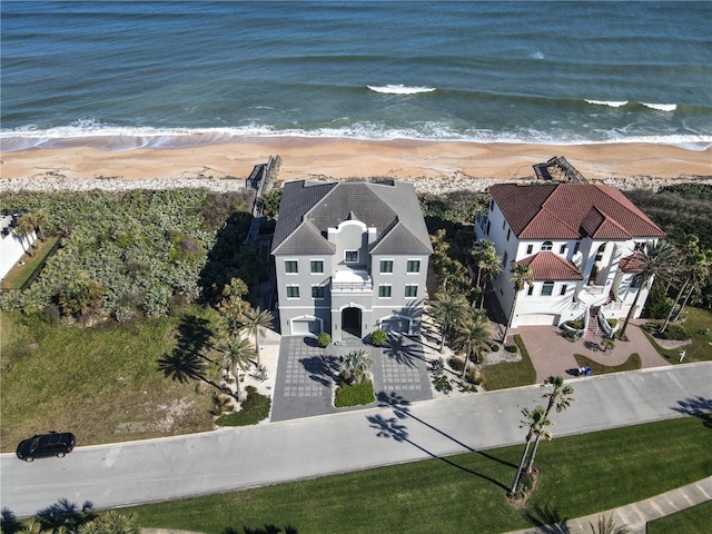 birds eye view of property with a water view and a beach view