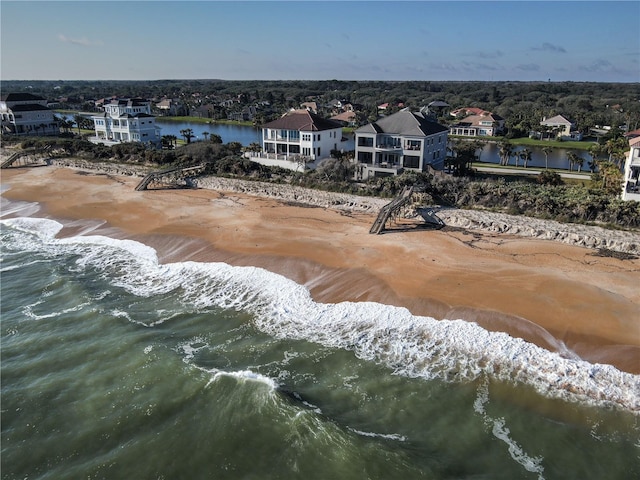 bird's eye view featuring a water view and a beach view