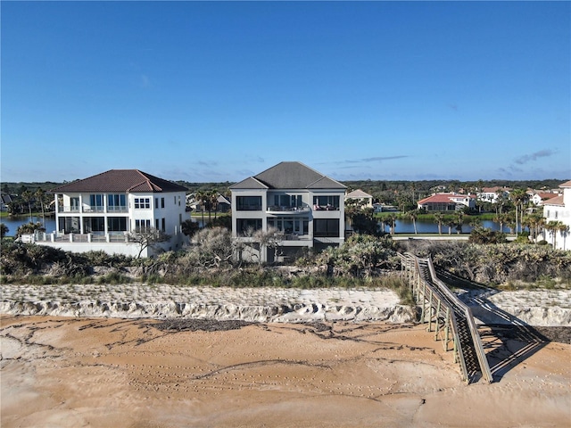 back of property featuring a water view and a balcony