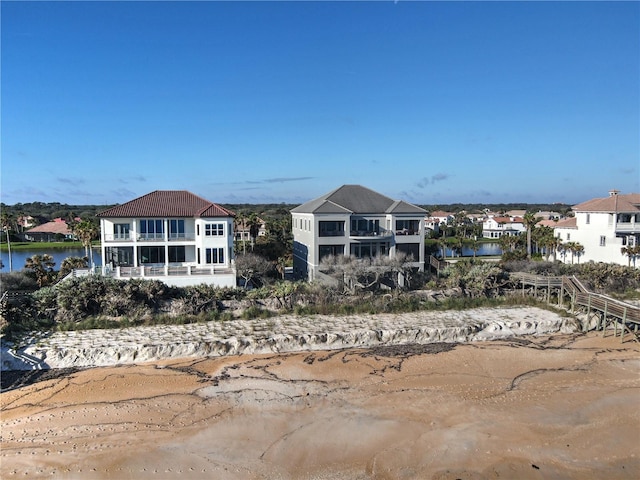 back of property with a balcony and a water view