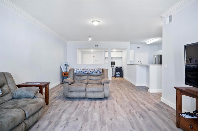 living room with light hardwood / wood-style floors and crown molding