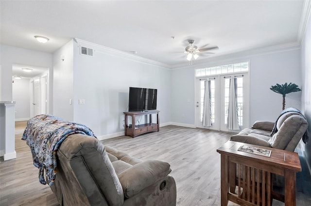 living room with light wood-type flooring, french doors, ceiling fan, and crown molding