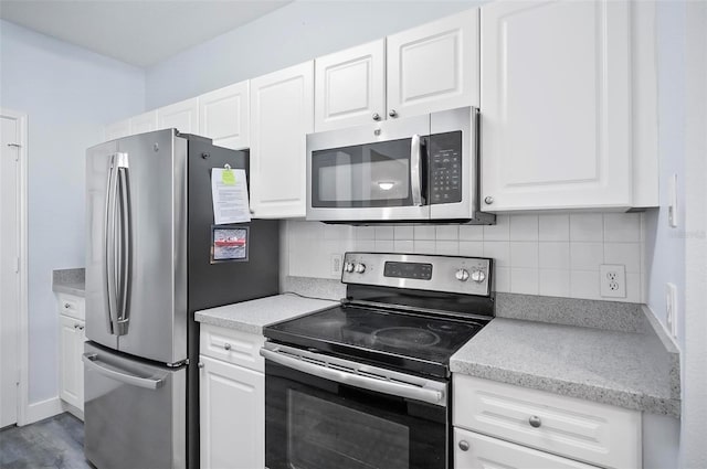 kitchen with stainless steel appliances, white cabinets, backsplash, and light wood-type flooring