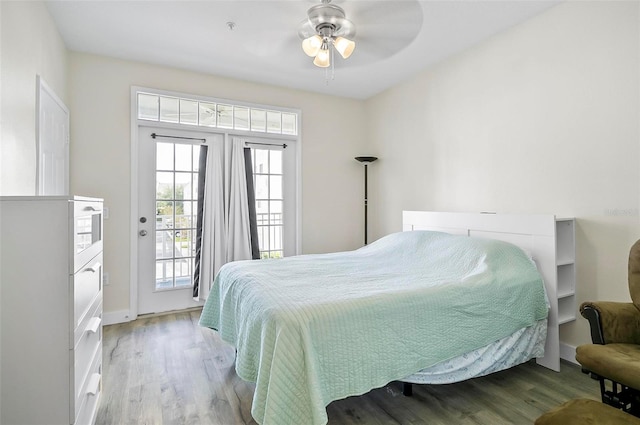 bedroom featuring access to outside, hardwood / wood-style flooring, and ceiling fan