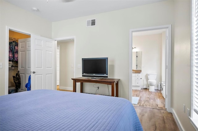 bedroom with a closet, light hardwood / wood-style flooring, and connected bathroom