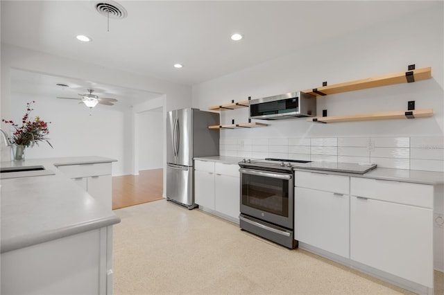 kitchen featuring tasteful backsplash, stainless steel appliances, ceiling fan, sink, and white cabinetry