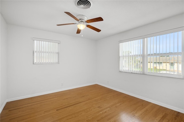 unfurnished room featuring hardwood / wood-style flooring, plenty of natural light, and ceiling fan