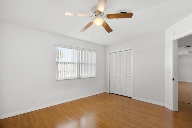 unfurnished bedroom featuring light hardwood / wood-style flooring, ceiling fan, and a closet