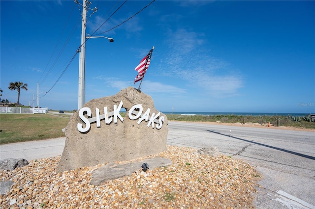 community / neighborhood sign with a water view