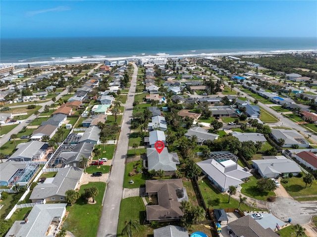 birds eye view of property with a water view and a view of the beach