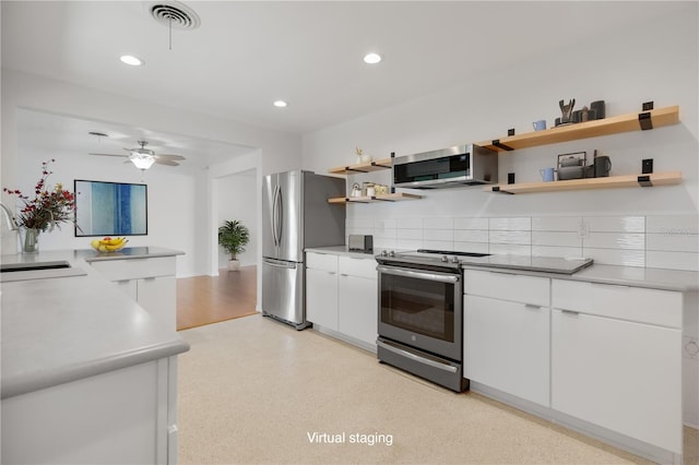 kitchen featuring decorative backsplash, appliances with stainless steel finishes, ceiling fan, sink, and white cabinets