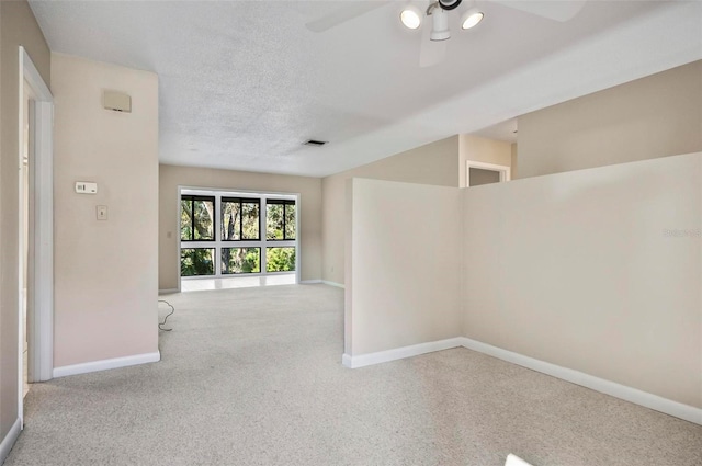 carpeted spare room with a textured ceiling and ceiling fan