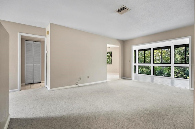 carpeted spare room with a textured ceiling