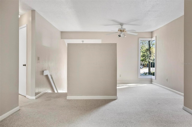 carpeted empty room featuring a textured ceiling and ceiling fan