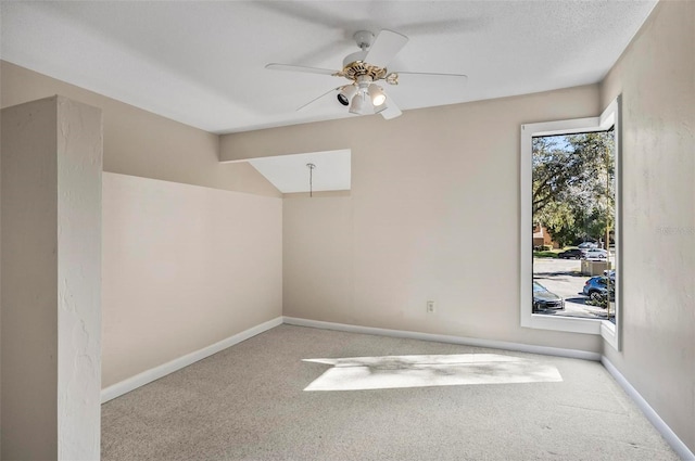 carpeted spare room featuring ceiling fan and a textured ceiling