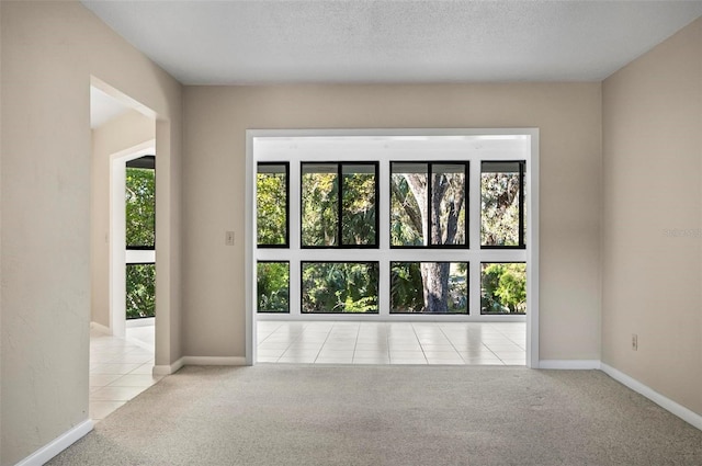 carpeted empty room with a textured ceiling