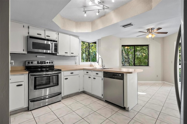 kitchen with a healthy amount of sunlight, sink, white cabinetry, and stainless steel appliances