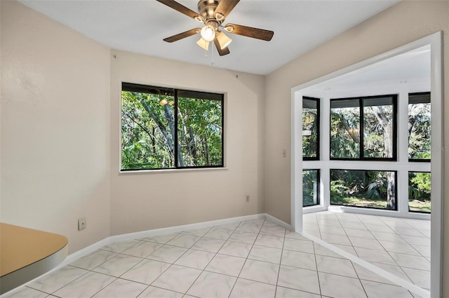 tiled empty room with plenty of natural light and ceiling fan