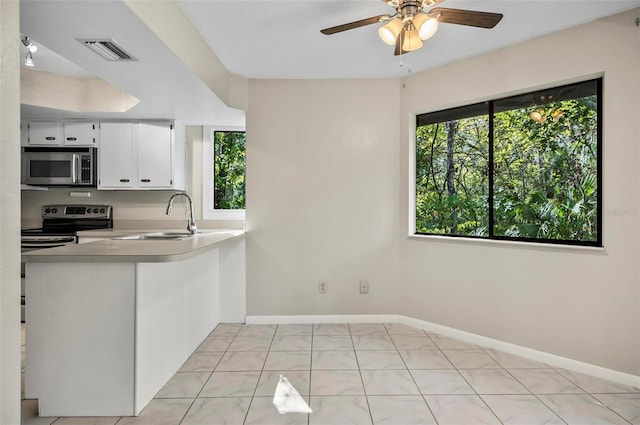 kitchen featuring white cabinetry, sink, stainless steel appliances, kitchen peninsula, and light tile patterned floors