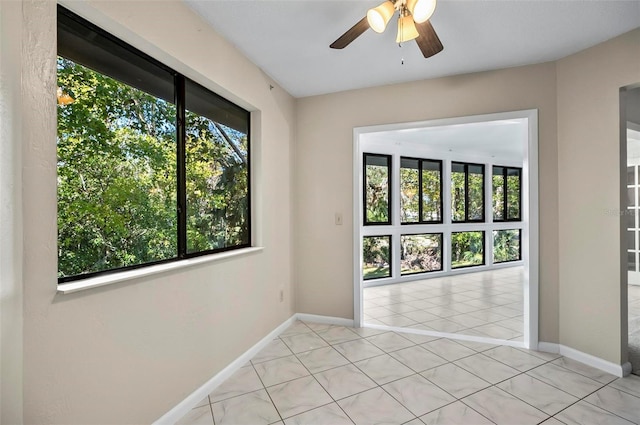 unfurnished room with ceiling fan and light tile patterned floors