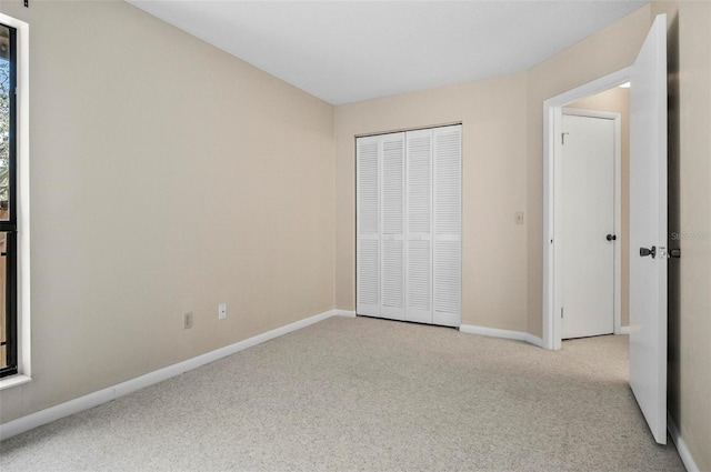 unfurnished bedroom with light carpet and a closet