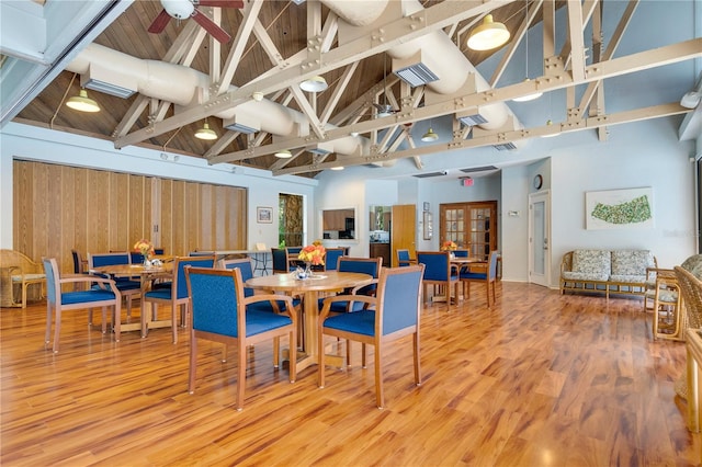 dining space featuring beam ceiling, ceiling fan, hardwood / wood-style floors, and high vaulted ceiling