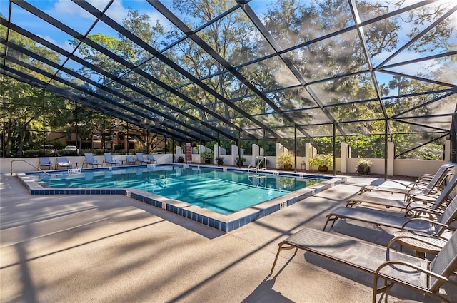 view of swimming pool with glass enclosure and a patio