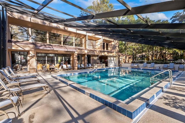 view of pool with glass enclosure and a patio