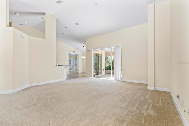 carpeted spare room with high vaulted ceiling