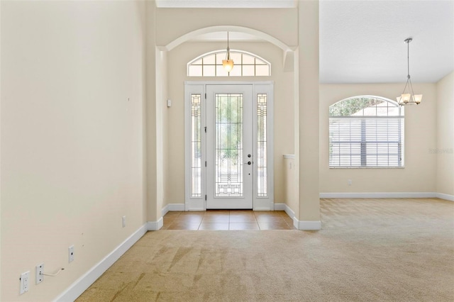 entryway with light colored carpet and an inviting chandelier