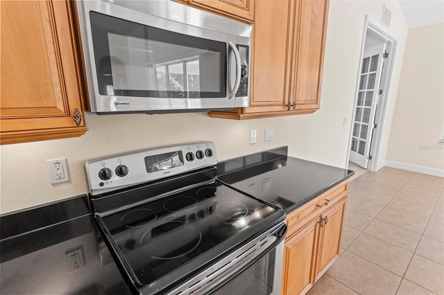 kitchen with appliances with stainless steel finishes and light tile patterned floors