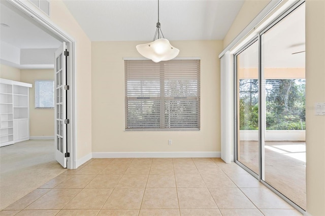 unfurnished dining area featuring light carpet and french doors