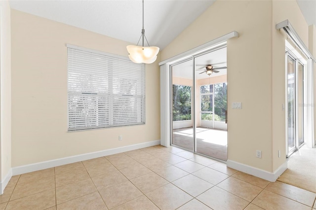 unfurnished dining area with vaulted ceiling, light tile patterned floors, and ceiling fan