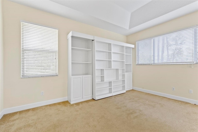 unfurnished bedroom with light colored carpet and multiple windows