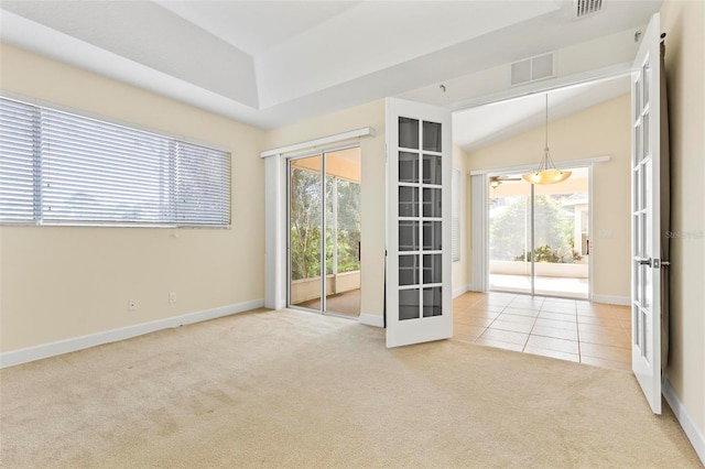 carpeted spare room with lofted ceiling and french doors